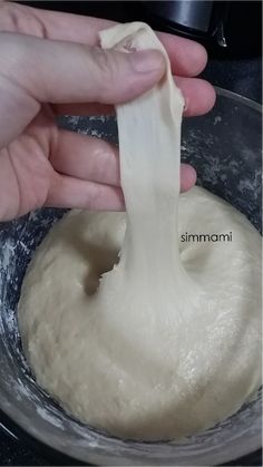 a person is mixing dough in a bowl