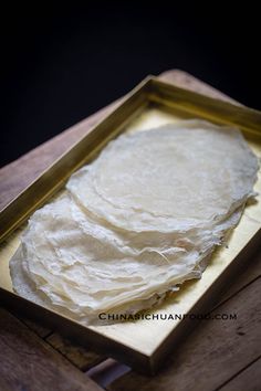 a pan filled with food sitting on top of a wooden table