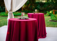 two tables with red cloths and white drapes