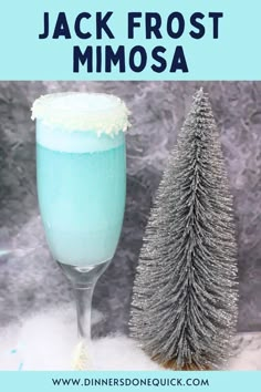 a glass filled with blue liquid next to a silver christmas tree and the words jack frost mimosa