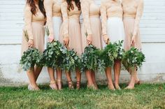 the bridesmaids are wearing long sleeved dresses and holding greenery in their hands