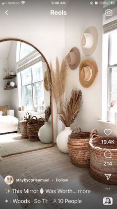 an image of a living room with mirrors and baskets on the floor in front of it