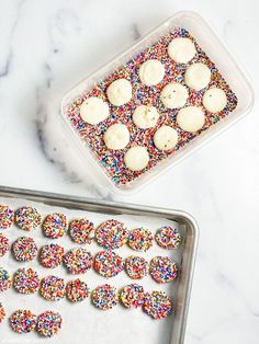 sprinkles and cookies are arranged on a cookie sheet next to a baking pan