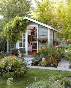 a garden shed with lots of flowers in it