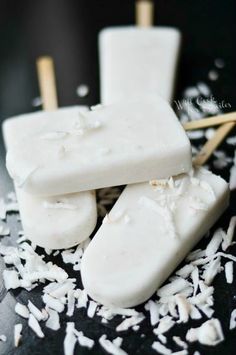 three pieces of white chocolate sitting on top of shredded coconut