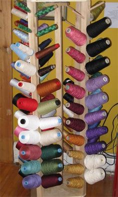 there are many spools of thread on the rack