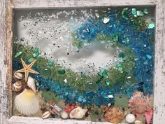 sea glass and seashells in an old window frame