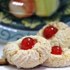 two cookies with cherries are on a plate