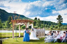 a bride and groom standing at the end of their wedding ceremony in front of a lake