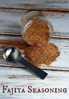 a spoon with some spices in it next to a jar on a wooden table that says fajita seasoning mix