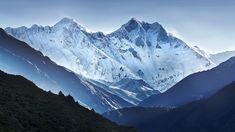 the mountains are covered in snow and clouds