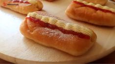 hotdogs with ketchup and mustard are on a cutting board, ready to be eaten