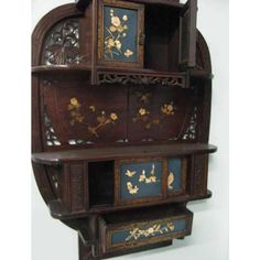 an ornate wooden shelf with flowers painted on the front and bottom shelves, along with other decorative items