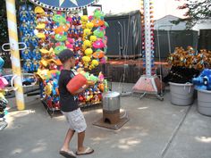 a young boy is playing with toys at an amusement park