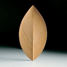 a close up of a wooden object on a white surface with a black back ground