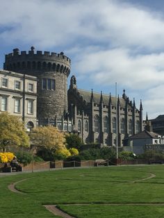 a large castle like building sitting on top of a lush green field