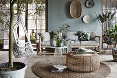 a living room filled with lots of furniture and potted plants on top of it