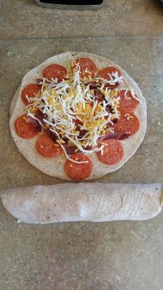 a pizza sitting on top of a pan covered in cheese and toppings next to a rolling pin