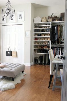 a living room with a chair, ottoman and closet