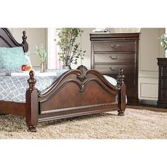 a bedroom with a bed, dresser and chest of drawers on carpeted flooring