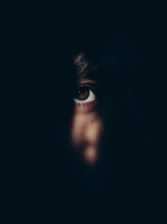 a person's face is shown through the dark