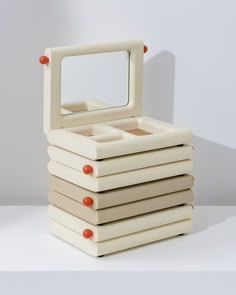 a stack of four boxes with a mirror on top of it, all stacked up