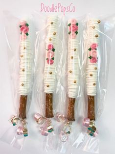 three candy sticks with flowers on them are wrapped in plastic