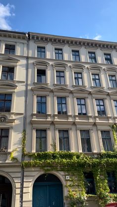 an apartment building with ivy growing on the side