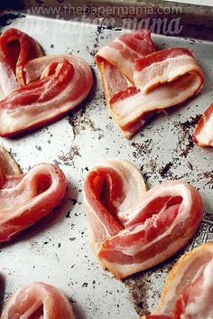 bacon in the shape of a heart on top of a sheet of tin foil next to an instagram page