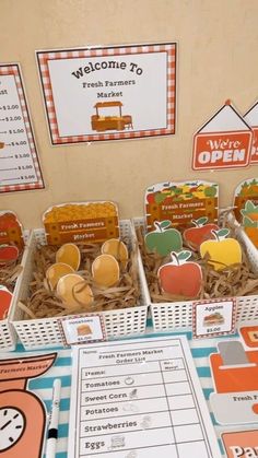 there are some apples and oranges in baskets on the table with other items for sale