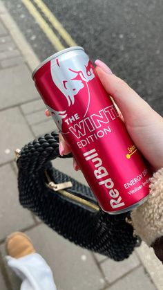 a person holding a can of red bull energy drink