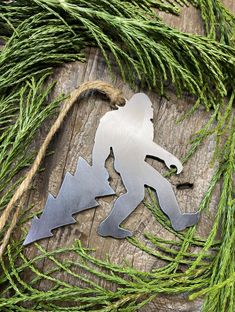 a metal ornament hanging from a tree branch on top of a wooden table