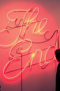 a neon sign that says fire and ice on the side of a pink wall with writing in cursive font