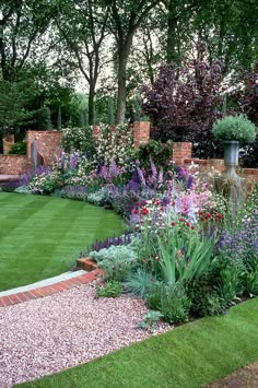 a garden with lots of different types of flowers and plants in the middle of it