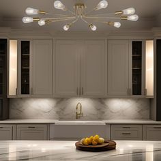 a kitchen with marble counter tops and white cupboards in the center, surrounded by gold accents