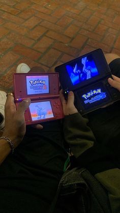 two people sitting on the ground playing with nintendo wii game console controllers in their hands