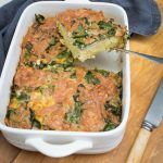 a casserole dish with broccoli and cheese in it on a wooden table