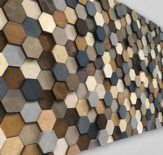 a large wooden wall sculpture with hexagon tiles on it's face and bottom