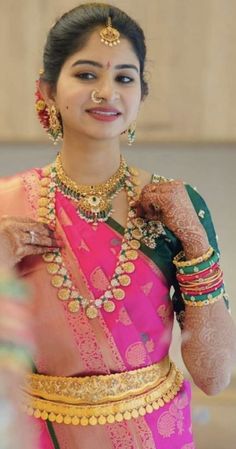 a woman in a pink and green sari