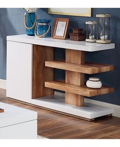 a white table with wooden shelves and pictures on it's sideboard next to a blue wall