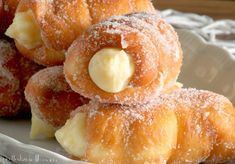 powdered sugar covered doughnuts on a white plate with butter in the middle