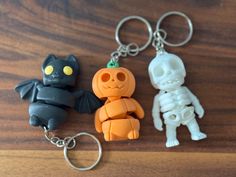 three halloween key chains on a wooden surface