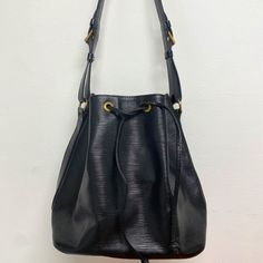 Louis Vuitton Stylish Black Epi Leather With Brass Hardware Size 10"W X 10.6"H X 7.5"D Approx Shoulder Drop:10.6 - 12.2inch Approx Style Shoulder Bag Includes Original Dust Bag Made In France Pre-Owned Conditiongood Used Condition With Wear On Bottom Edges, Leather Tie And Hardware And Minor Wear On Shoulder Strap, Minor Scratches On Hardware Clean Smoke Free Home Black Bucket Satchel With Gold-tone Hardware, Versatile Black Bucket Bag With Gold-tone Hardware, Louis Vuitton Epi Bucket Bag, Luxury Black Leather-lined Bucket Bag, Luxury Pouch-shaped Bucket Bag With Adjustable Strap, Leather Tie, Shoulder Bag Black, Brass Hardware, Made In France