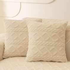 two white pillows sitting on top of a bed