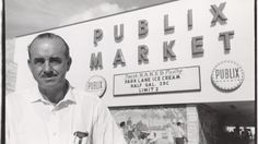 a man standing in front of a public market sign with his hands on his hips