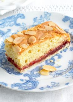 a piece of cake sitting on top of a blue and white plate with almonds