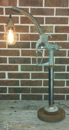 an old fashioned lamp on a table next to a brick wall with a light bulb