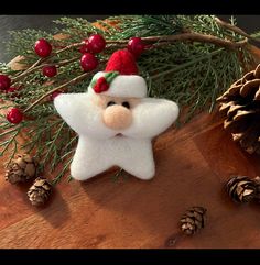 a christmas ornament on a table with pine cones