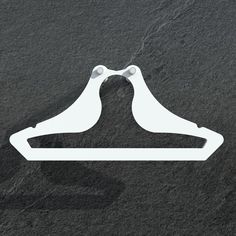 a pair of white clothes hangers sitting on top of a black surface