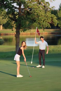 a man and woman playing golf on the green